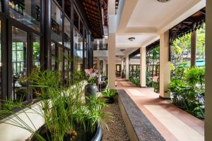 a corridor of a building with potted plants at Saem Siemreap Hotel in Siem Reap