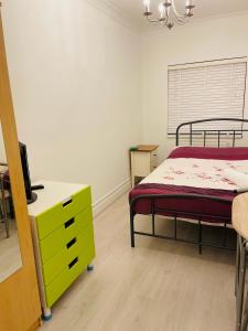 a bedroom with two beds and a yellow dresser at London Rooms with Free Parking 134 in Stone Grove