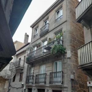um edifício com varandas e plantas ao lado dele em La Guinda Real em Vigo