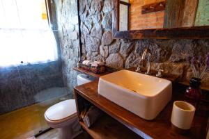 a bathroom with a sink and a toilet at Chales Canto da Natureza in São Bento do Sapucaí