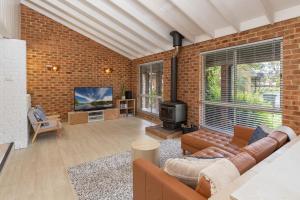 a living room with a couch and a tv at Tulloch Estate in Tuncurry