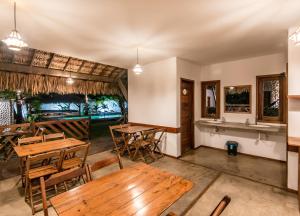Barra Grande Beach Club في بارا غراندي: غرفة طعام مع طاولات وكراسي خشبية