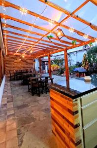 un patio al aire libre con mesas y una pérgola de madera. en San Gabriel Hospedería en Tibasosa
