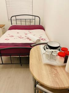 a bed with a table with a tray of food on it at London Rooms with Free Parking 134 in Stone Grove