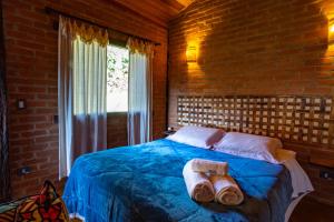a bedroom with a bed with two shoes on it at Chales Canto da Natureza in São Bento do Sapucaí