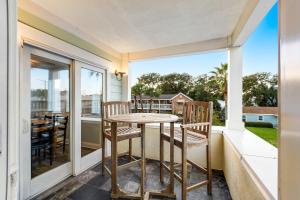a patio with a table and chairs on a balcony at Berniewood in Tybee Island