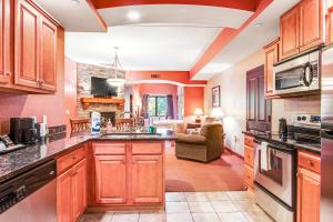 a kitchen with wooden cabinets and a living room at Chula Vista Condo 2251 in Wisconsin Dells