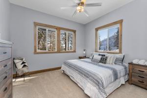 a bedroom with a bed and two windows at Antoine Cabin in Chelan