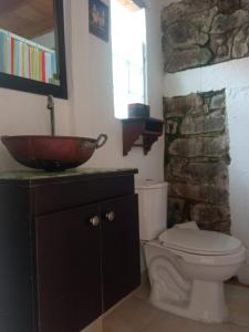 a bathroom with a toilet and a bowl sink at Cucunuba por Siempre in El Salitre
