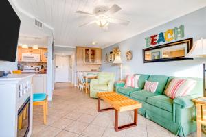 a living room with a green couch and a kitchen at Sand Dollar Villas 109 in Fernandina Beach