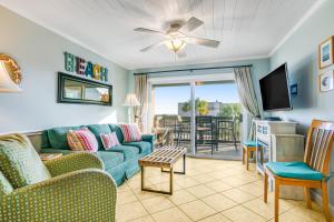 a living room with a couch and a tv at Sand Dollar Villas 109 in Fernandina Beach