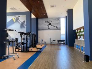 une salle de sport avec des appareils d'exercice et un mur avec une photo dans l'établissement Camino al Mar 1702 Vista al Mar, à Mazatlán