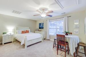 a bedroom with a bed and a table and a ceiling fan at Southern Charm Getaway in Charleston