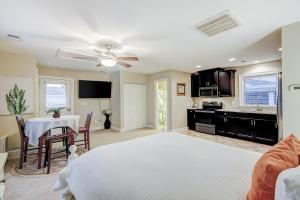 a bedroom with a white bed and a kitchen with a table at Southern Charm Getaway in Charleston