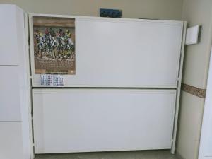 um frigorífico branco num quarto com um cartaz em SOLEA 17 em Rota