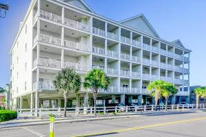 マートルビーチにあるCoconut Grove 405のヤシの木が前に立つ大きな白い建物