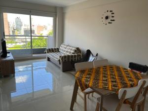 sala de estar con mesa y sofá en Bellísimo departamento de un dormitorio, ubicación inmejorable en Rosario