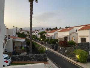 a city street with houses and a palm tree at Juangy’s Apartments in Las Adelfas Golf del Sur in San Miguel de Abona