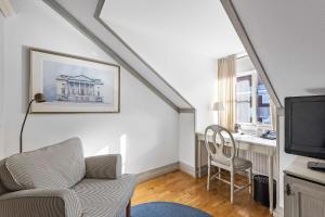 a living room with a couch and a television at Best Western Plus Edward Hotel in Lidköping