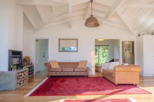 彭特派因的住宿－Sunset Villa Norfolk Island - a Mediterranean inspired villa，客厅配有两张沙发和红色地毯