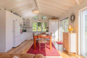 cocina con mesa de madera y cocina con nevera en Sunset Villa Norfolk Island - a Mediterranean inspired villa en Burnt Pine