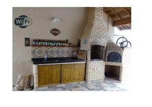 a kitchen with a counter and a brick oven at Casa Peruibe. in Peruíbe