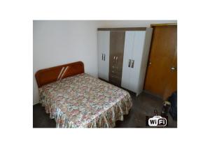 a bedroom with a bed and a closet with a door at Casa Peruibe. in Peruíbe