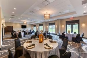 a conference room with tables and chairs and a screen at Best Western Premier Northwood Hotel in Timmins