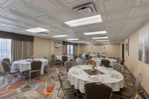 una sala de conferencias con mesas y sillas blancas en Best Western Plus Rose City Suites, en Welland