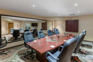 une salle de conférence avec une grande table et des chaises en bois dans l'établissement Best Western Plus Rose City Suites, à Welland