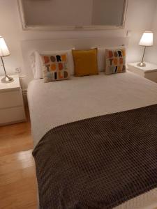 1 dormitorio con 1 cama con almohadas y 2 lámparas en Lolla's Dream House, en Oporto