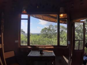a room with a window and a table with a view at Ecohostel Tay Pichin in San Marcos Sierras