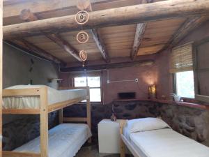 1 dormitorio con 2 literas en una cabaña en Ecohostel Tay Pichin en San Marcos Sierras