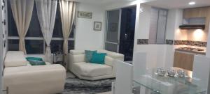 een woonkamer met 2 stoelen en een tafel bij Moderno amplio y acogedor apartamento en el sur de cali in Cali