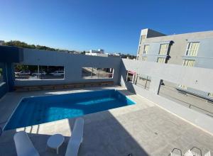 a swimming pool in the backyard of a house at Hotel Torrevado in Las Grutas