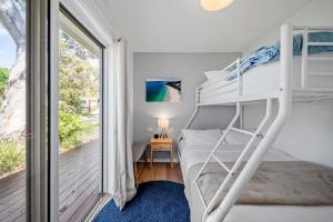 a bedroom with a bunk bed and a balcony at Elements of Hyams in Hyams Beach