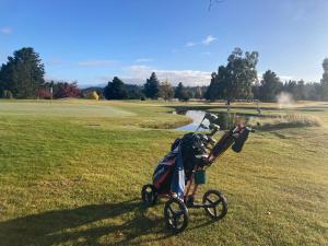 a stroller parked on the grass next to a golf course at Lookout Escape Studio, Alexandra in Alexandra