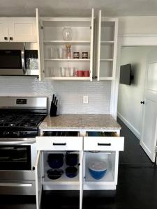 cocina con armarios blancos y fogones en Modern Three Bedroom Condo - Boston en Stoneham