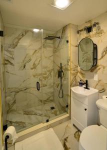y baño con ducha, aseo y lavamanos. en Modern Three Bedroom Condo - Boston en Stoneham