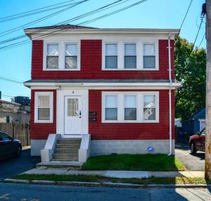 una casa roja con una puerta blanca en una calle en Modern Three Bedroom Condo - Boston en Stoneham