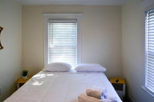 1 dormitorio con 1 cama con 2 almohadas y ventana en Modern Three Bedroom Condo - Boston en Stoneham