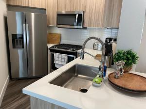 a kitchen with a sink and a stainless steel refrigerator at Lovely 2/2 apartment in heart of Santa Monica with free parking in Los Angeles