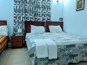 a bedroom with a large bed with a blanket at Hotel Aluge in Santo Domingo