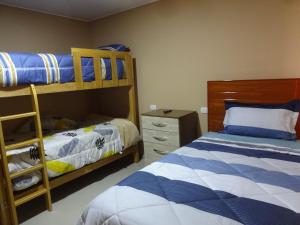 a bedroom with two bunk beds and a dresser at Matty House in Lima