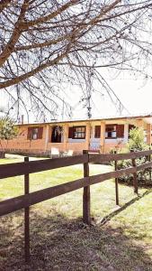 a wooden fence in front of a house at Pousada Rural Capão das Vertentes in Cambara do Sul