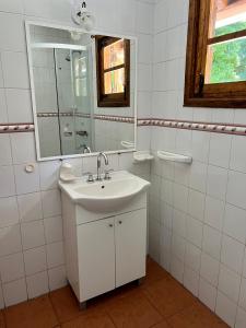 a white bathroom with a sink and a mirror at Casa Estilo Cabaña, Bosque Peralta Ramos in Mar del Plata