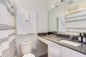 a white bathroom with a toilet and a sink at 2BR 2BA The Ballard Modish, Seattle Location with rooftop view in Seattle