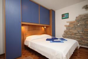 una camera da letto con letto, armadi blu e parete in pietra di Seaside holiday house Novigrad - 3365 a Novigrad Istria