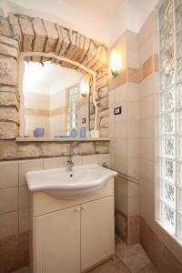 bagno con lavandino e parete in pietra di Seaside holiday house Novigrad - 3365 a Novigrad Istria
