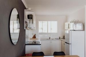 a kitchen with a mirror and a white refrigerator at Sweetwater Villas in St Helens